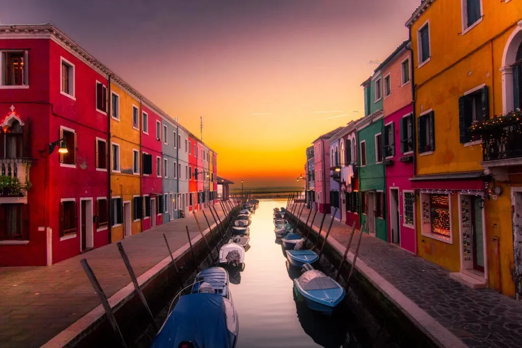 Colourful canal street with boats at sunset