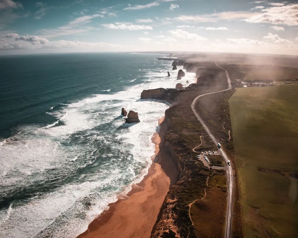Coastal cliffs with ocean waves and a road running along the shoreline