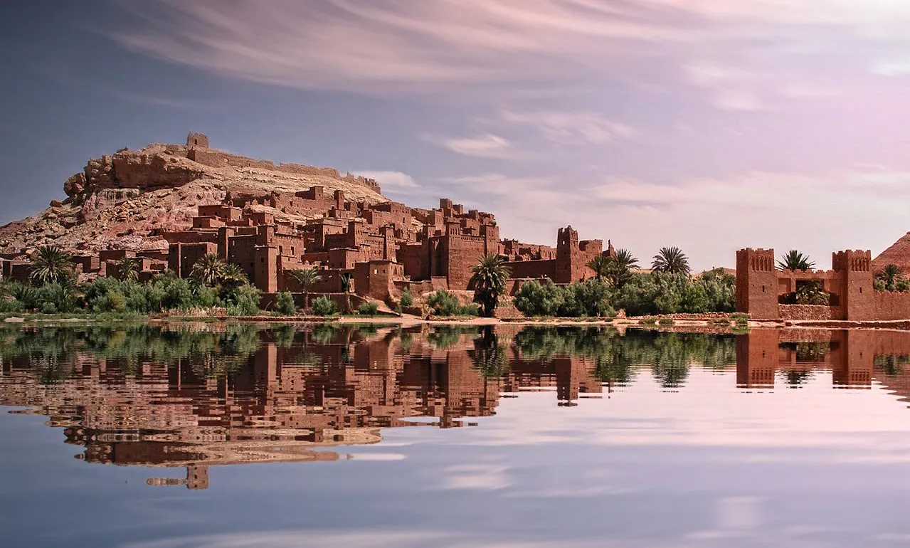 Ancient desert fortress reflected in a calm river