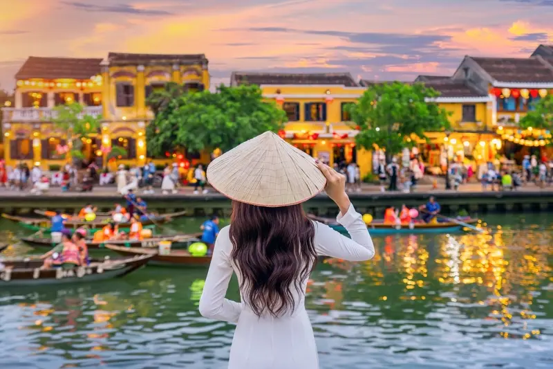 Woman in conical hat by river
