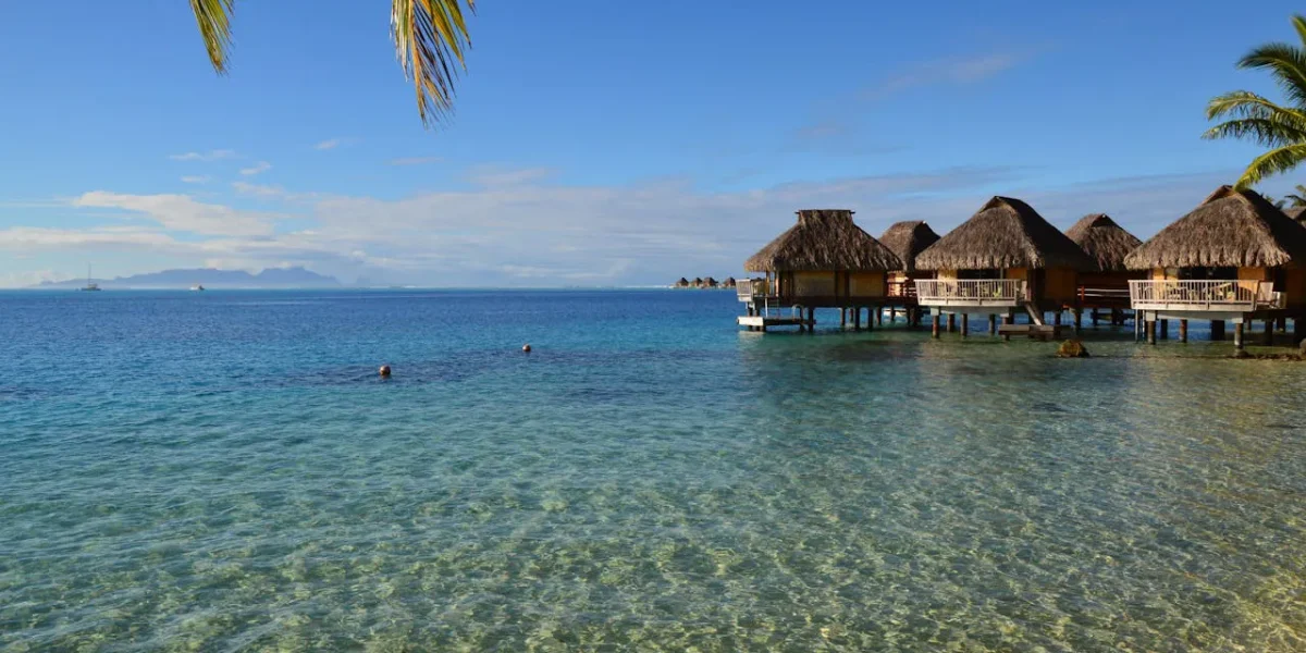 Tropical overwater bungalows by clear water