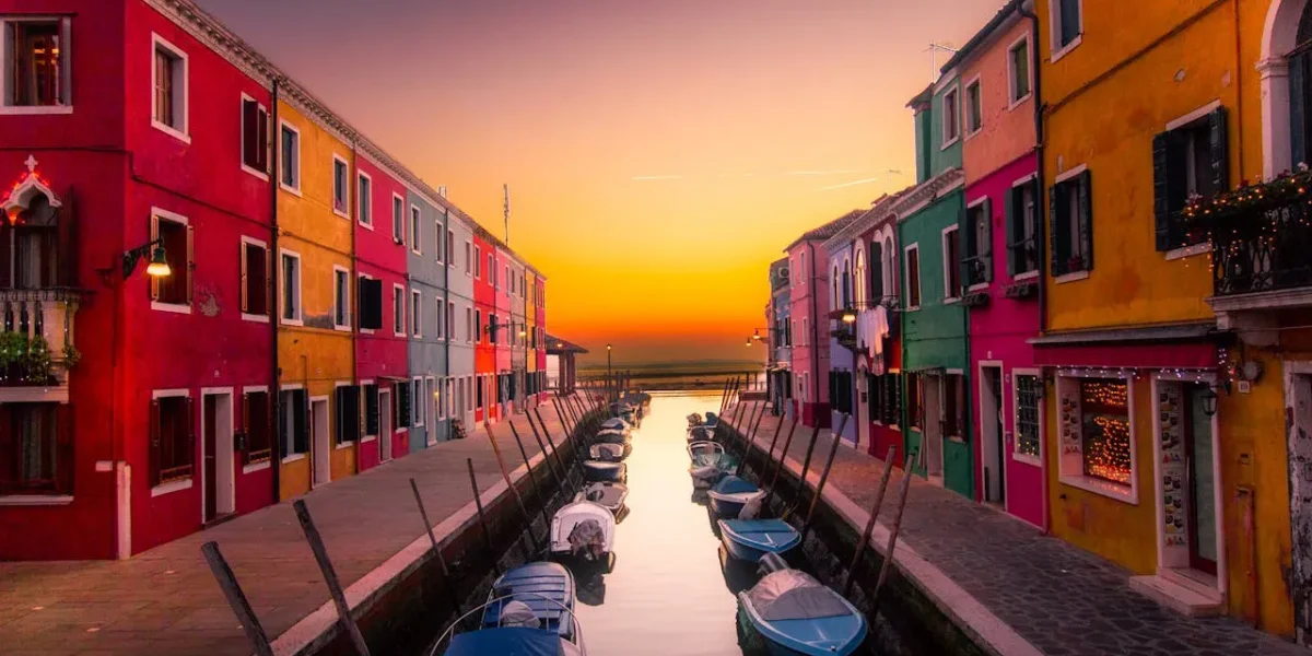 Colourful canal street with boats at sunset